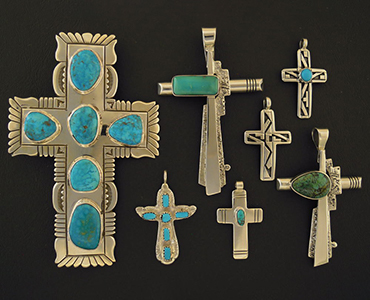 6 cross pendants organized from largest to smallest.